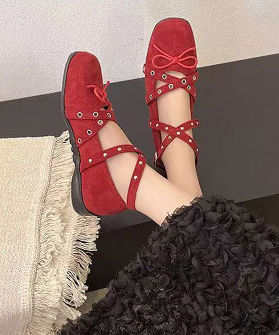 Chaussures à brides plates rouges en daim avec nœud croisé et rivets
